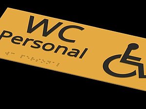 gelbes Schild mit Aufschrift in schwarz und Braille: WC Personal und Icon Person im Rollstuhl