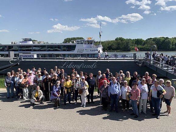 Ausflug_Wachau_Gruppenbild_vor_Faehre.jpg Gruppe von ca 50 Menschen vor Fähre bei sonnigem Wetter