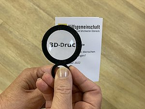 Lupe vergrößert Begriff auf Zettelchen: "3D Druck"