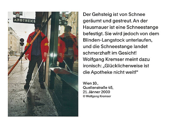 Links Foto eines Mannes, der mit einem Weißen Stock am Gehsteig geht. Hinter ihm sieht man das Schild einer Apotheke. Im Weg lehnt ihm eine Dachlawinen-Stange. Rechts Text: "Der Gehsteig ist von Schnee geräumt und gestreut. An der Hausmauer ist eine Schneestange befestigt. Sie wird jedoch von dem Blinden-Langstock unterlaufen, und die Schneestange landet schmerzhaft im Gesicht! Wolfgang Kremser meint dazu ironisch: "Glücklicherweise ist die Apotheke nicht weit!" Wien 10., Quellenstraße 45, 21. Jänner 2000, © Wolfgang Kremser"
