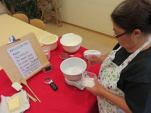 Frau verwendet Hilfsmittel beim Backen von Kuchen