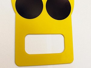 Gelbes Plastikschild mit drei schwarzen Punkten und Griff unten