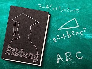 Buch mit Aufschrift "Bildung" und mathematische Formeln