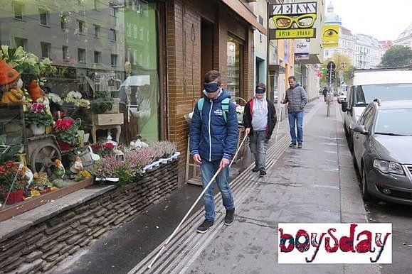 Zwei Jungen sind mit Langstock und Augenbinden draußen unterwegs, Copyright: Boysday