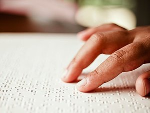 Nahaufnahme Finger streichen über Braille Text