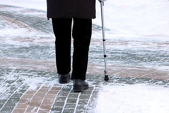 Mobilitaet_im_Winter_Hilfsgemeinschaft_der_Blinden_und_Sehschwachen_OEsterreichs.jpg ältere Person von hinten mit Gehstock auf Schneeboden