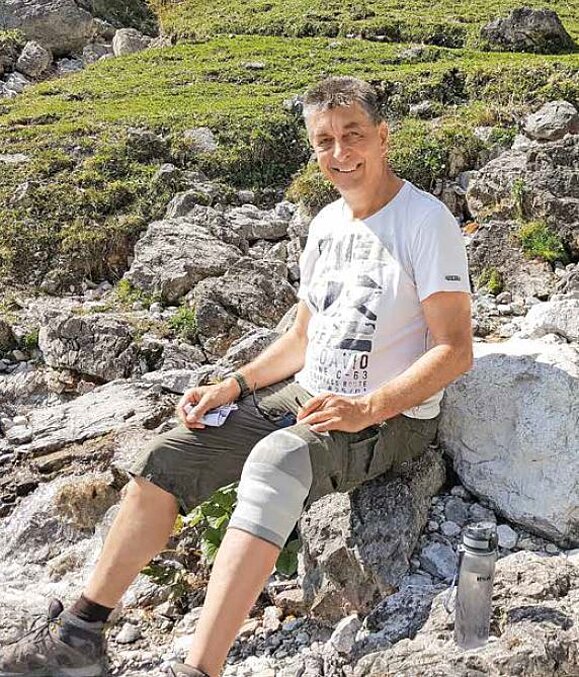 Christian_Schwarzl-Behindertenbeauftragter_2-Hilfsgemeinschaft_der_Blinden_und_Sehschwachen.JPG Mann mit Wanderhose sitzt auf Stein und lacht in die Kamera