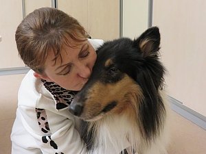 Eine Frau küsst Blindenführhund Lilli auf die Schnauze
