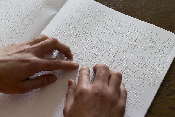 Hände ertasten Brailleschrift