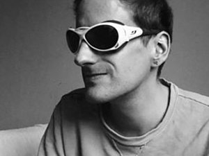 Ein Schwarz-Weiß Foto von einem Mann mit Brille.